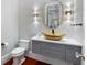 Unique half bathroom features a gold basin sink, modern lighting, and sleek gray cabinets at 980 Fenimore Cir, Atlanta, GA 30350