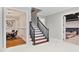 Hallway with white tile, staircase with dark wood treads and spindles, plus a dining room and theater room at 980 Fenimore Cir, Atlanta, GA 30350