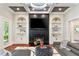 Elegant living room featuring a fireplace, built-in shelves, a modern chandelier and hardwood floors at 980 Fenimore Cir, Atlanta, GA 30350