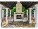 Inviting outdoor fireplace with hanging egg chairs on a stone patio beneath an elegant pergola at 980 Fenimore Cir, Atlanta, GA 30350