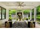 Stylish screened porch with comfortable seating, outdoor fireplace, and a view of the manicured yard at 980 Fenimore Cir, Atlanta, GA 30350