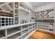 Spacious walk-in wine cellar with custom white shelving for ample bottle storage and hardwood floors at 980 Fenimore Cir, Atlanta, GA 30350