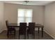 Formal dining room with wood-like floors, a window and a wooden table set for four at 985 Romer Pl, Stone Mountain, GA 30083