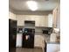 Bright kitchen features white cabinets, granite countertops, and black appliances at 985 Romer Pl, Stone Mountain, GA 30083