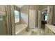 Bathroom featuring a soaking tub, window, striped wallpaper, and a door leading to the bedroom at 1008 Post Horn Run, Lawrenceville, GA 30045