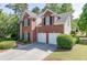 Rear exterior of a brick house, highlighting the two-car garage and well-kept lawn at 1008 Post Horn Run, Lawrenceville, GA 30045