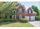 Charming two-story brick home with a well-manicured lawn and a two-car garage at 1008 Post Horn Run, Lawrenceville, GA 30045