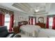 Expansive main bedroom featuring tray ceilings, red curtains, and a comfortable seating area at 1008 Post Horn Run, Lawrenceville, GA 30045