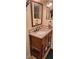 Bathroom vanity with dark wood cabinet, granite countertop and tiled backsplash with a framed mirror at 1638 Raleigh Cir, Marietta, GA 30067