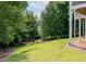Lush green backyard with mature trees, lake view, and patio area beneath a raised deck at 2909 Redding Road Northeast, Atlanta, GA 30319