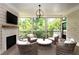 Inviting screened porch with fireplace, TV, and comfortable seating surrounded by lush greenery at 2909 Redding Road Northeast, Atlanta, GA 30319