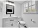 Bright bathroom featuring a white vanity, toilet, and a window with privacy shutters at 3244 Beechwood Se Dr, Marietta, GA 30067