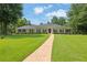 Charming ranch-style home featuring a manicured lawn, stone walkway, and a classic red front door at 3244 Beechwood Se Dr, Marietta, GA 30067