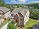 Aerial view of brick home with landscaped yard, driveway, and surrounding neighborhood at 4480 Egret Ave, Cumming, GA 30041