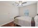 Cozy bedroom featuring hardwood floors, a ceiling fan, and a window at 4480 Egret Ave, Cumming, GA 30041