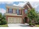 Attractive two-story brick home boasting a two-car garage, manicured shrubs, and inviting entrance at 4480 Egret Ave, Cumming, GA 30041