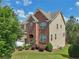 Two-story home with brick and siding, manicured lawn, and mature trees in a suburban setting at 4480 Egret Ave, Cumming, GA 30041