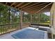 Relaxing covered patio featuring a comfortable outdoor seating area and view of lush trees at 4480 Egret Ave, Cumming, GA 30041