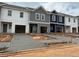 Newly constructed townhomes featuring attached garages, varied siding colors and freshly poured concrete driveways at 1346 Riverstone Rd # 107, Jonesboro, GA 30238