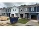 New townhomes with garages, showcasing stylish exteriors and freshly landscaped lawns at 1346 Riverstone Rd # 107, Jonesboro, GA 30238