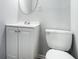 This bathroom features a white vanity with a round mirror and modern fixtures at 2480 Washington Street Ext # 2482, Austell, GA 30106