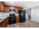 Finished basement kitchenette featuring a black fridge, stove, wood cabinets, granite countertops and stairs to the main floor at 2480 Washington Street Ext # 2482, Austell, GA 30106