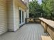 Corner of a wooden deck featuring a door and view to the green backyard at 5619 Wandering Vine Se Ln, Mableton, GA 30126