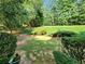 A flat and green backyard featuring garden beds and various green bushes at 5619 Wandering Vine Se Ln, Mableton, GA 30126