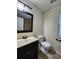 A neutral colored bathroom featuring a single sink vanity and tiled shower at 5619 Wandering Vine Se Ln, Mableton, GA 30126