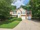 Charming two-story brick home featuring a well-manicured lawn and a two-car garage at 5619 Wandering Vine Se Ln, Mableton, GA 30126