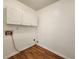 A corner of a laundry room with hardwood floors and white cabinets at 5619 Wandering Vine Se Ln, Mableton, GA 30126