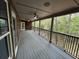 Spacious covered back porch features a ceiling fan and views of the lush, wooded backyard at 1713 Cagle Ct, Lawrenceville, GA 30045