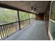 Spacious covered back porch features a ceiling fan and views of the lush, wooded backyard at 1713 Cagle Ct, Lawrenceville, GA 30045