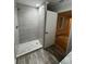 Modern bathroom features a glass-enclosed shower with stone floor and gray tiled walls at 1713 Cagle Ct, Lawrenceville, GA 30045