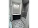 Contemporary bathroom with dark vanity, patterned floors, and a glass-enclosed shower, exuding modern elegance at 1713 Cagle Ct, Lawrenceville, GA 30045