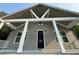 Eye-level, low angle shot of a home's entrance with white columns and a modern black door at 1713 Cagle Ct, Lawrenceville, GA 30045