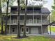 Multi-level deck home exterior view with two decks, a two-car garage, a covered carport, and landscaped yard at 1713 Cagle Ct, Lawrenceville, GA 30045