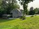 Exterior view of a gray two-story house with a covered parking area, showcasing its backyard and green lawn at 1713 Cagle Ct, Lawrenceville, GA 30045