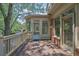 A wood balcony showing the sunroom, brickwork, exterior lights, and entry doors at 2010 Riverside Rd, Roswell, GA 30076