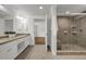 Bright bathroom featuring double vanity, walk-in shower with glass door and neutral tile at 2010 Riverside Rd, Roswell, GA 30076
