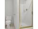 A clean, bright bathroom featuring a toilet and glass shower with gold fixtures at 2010 Riverside Rd, Roswell, GA 30076
