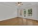 A bedroom with hardwood floors, white trim, tray ceilings and door to a balcony with wooded views at 2010 Riverside Rd, Roswell, GA 30076