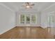 A bedroom with hardwood floors, white trim, tray ceilings and a door to a sunroom at 2010 Riverside Rd, Roswell, GA 30076
