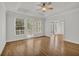 A bedroom features a tray ceiling, hardwood floors, and a view to the sunroom and a door to a balcony at 2010 Riverside Rd, Roswell, GA 30076