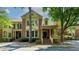 Charming brick townhome featuring a welcoming entrance, front porch, and manicured landscaping at 2010 Riverside Rd, Roswell, GA 30076