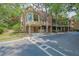 Multi-story exterior features attached garage, balconies, and mature trees in a wooded setting at 2010 Riverside Rd, Roswell, GA 30076