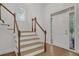 Bright foyer featuring hardwood floors, staircase, and a decorative stained glass window by the front door at 2010 Riverside Rd, Roswell, GA 30076