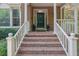 Inviting front porch with brick steps, white railings, and a beautifully decorated front door at 2010 Riverside Rd, Roswell, GA 30076