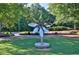 Shiny flower sculpture in a park setting with benches and greenery, framed by mature trees at 2010 Riverside Rd, Roswell, GA 30076