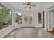 Bright sunroom featuring neutral tile floor, a ceiling fan, and large windows with views of the neighborhood at 2010 Riverside Rd, Roswell, GA 30076
